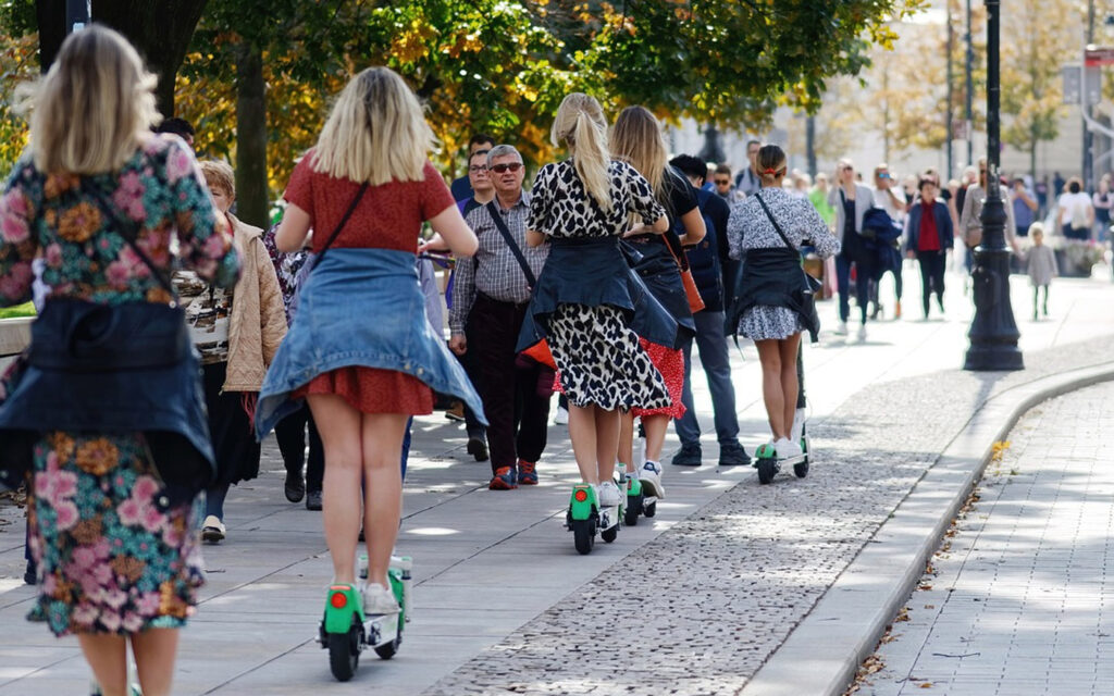 modisch gekleidete junge Leute auf Rollern / Scooter / Mode